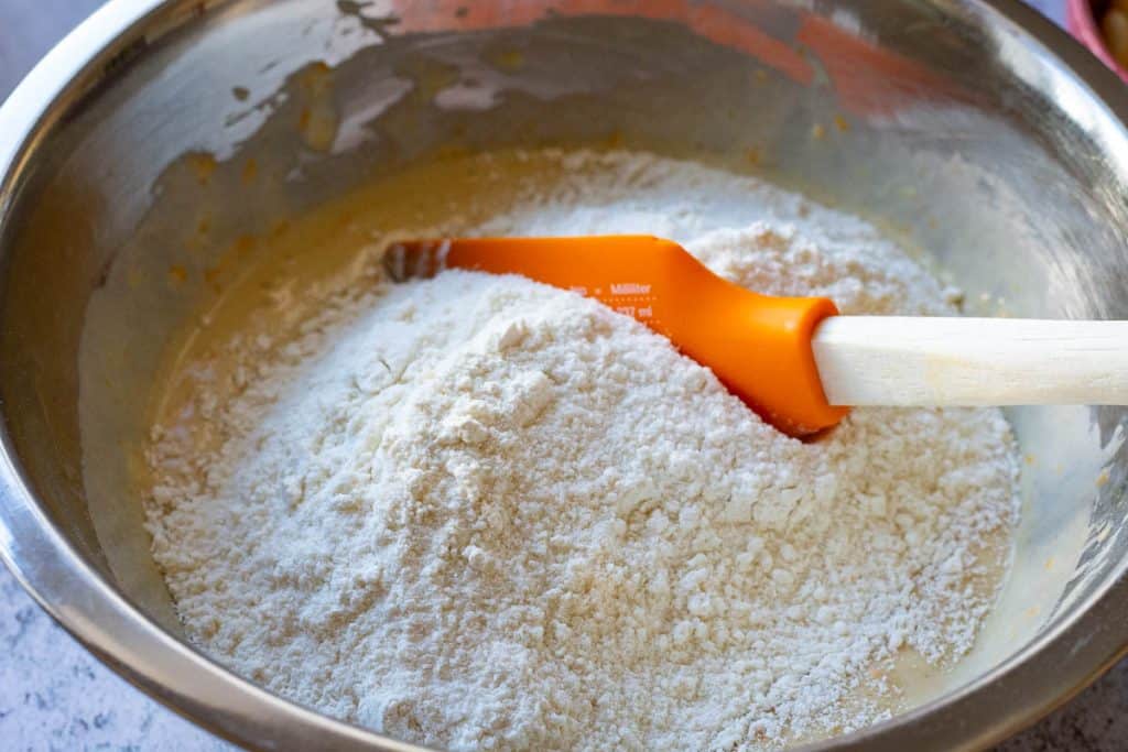 Folding dry ingredeints into wet ingredeints with a rubber spatula.