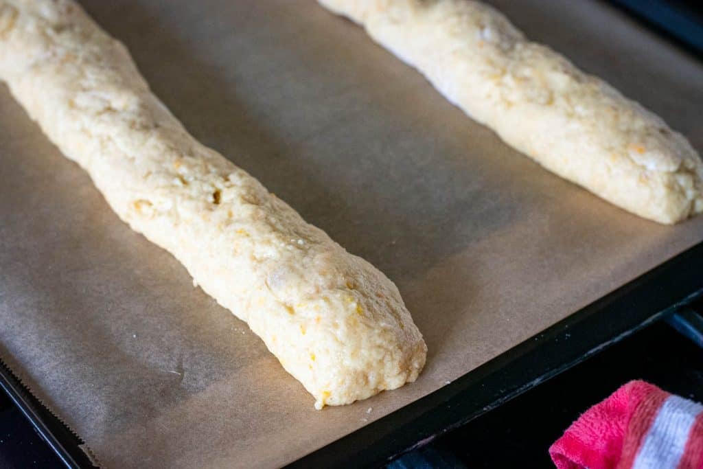 Two sourdough discard biscotti dough logs on a baking sheet.