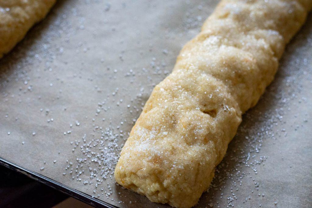 Dough log brushed with egg white and sprinkled with sugar.