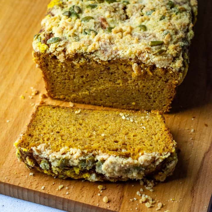 One slice of sourdough discard pumpkin bread cut on a wooden board.