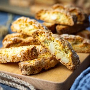 Orange and Almond Sourdough Biscotti stacked on a wooden board.