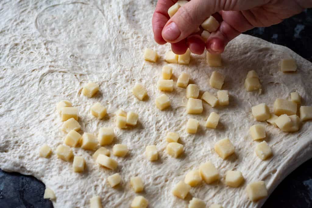 Scattering cubed marzipan onto the sourdough.