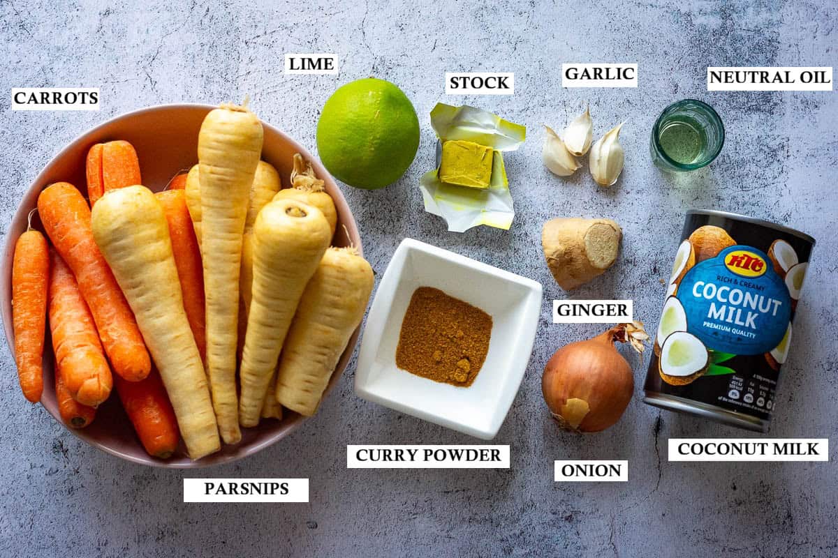 Labelled ingredients for Curried Parsnip and Carrot Soup on a light grey surface.