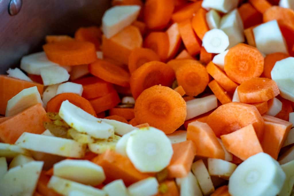 Sliced carrots and parsnips in a large pot.
