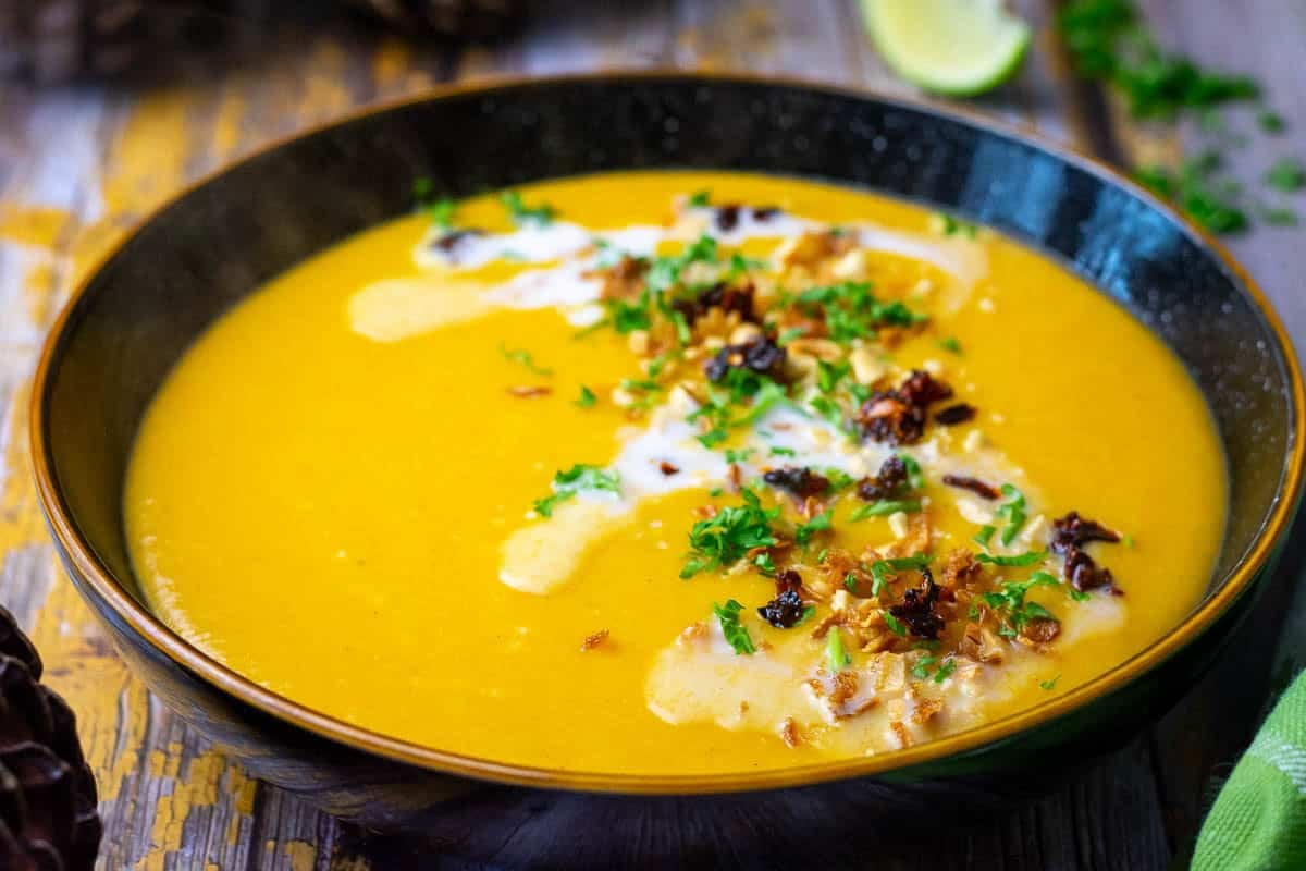 Carrot Parsnip Soup topped with coconut milk, crispy onions, chilli and peanuts.
