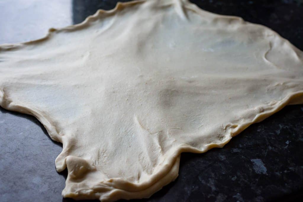 Sourdough stretched out into a large rectangle on the kitchen worktop.