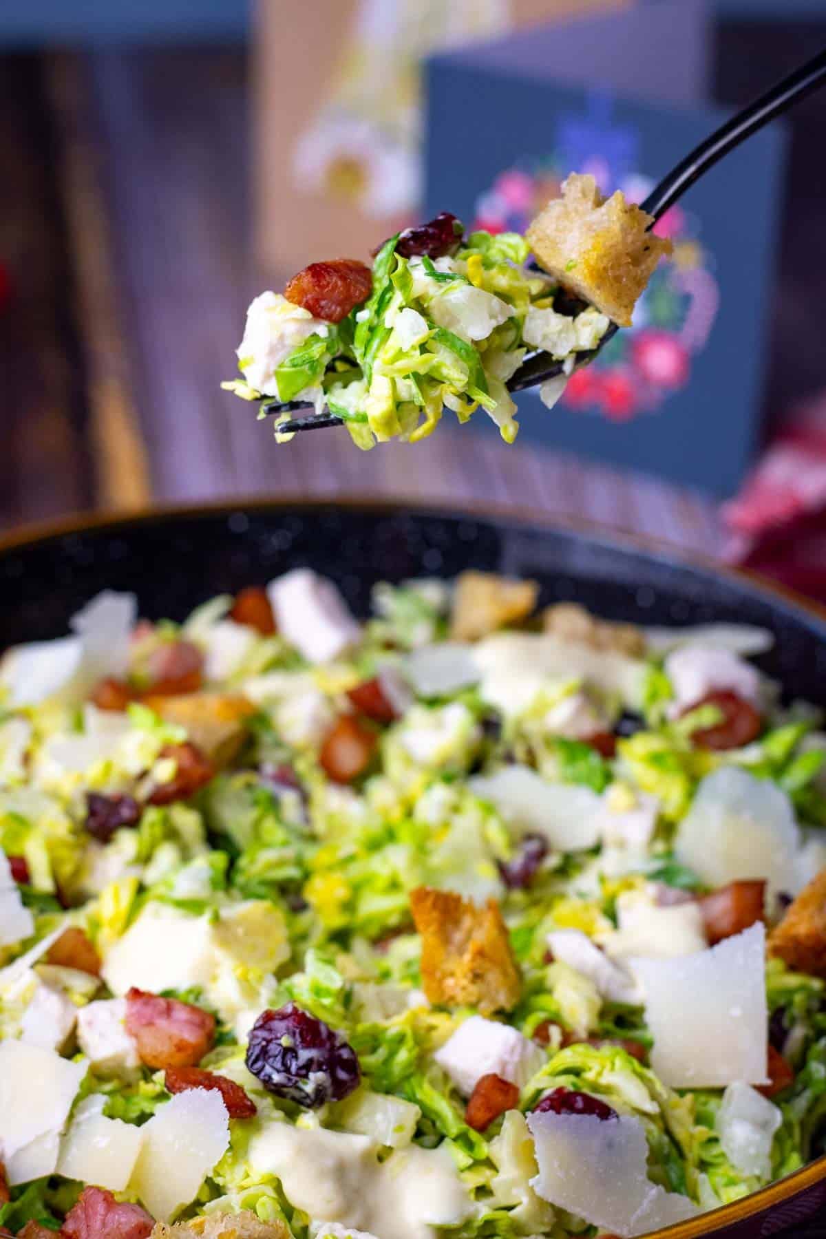 A forkful of Christmas leftover caesar salad being scooped up form the bowl.