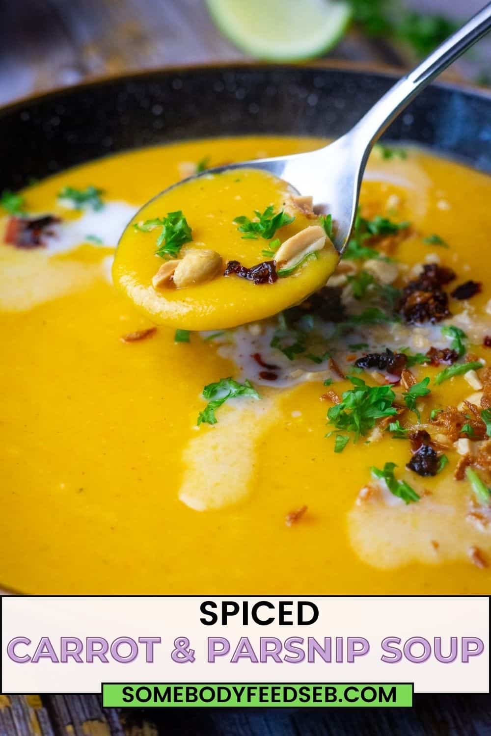A spoonful of Curried Carrot and Parsnip soup being lifted out of the bowl. Pin for Pinterest.