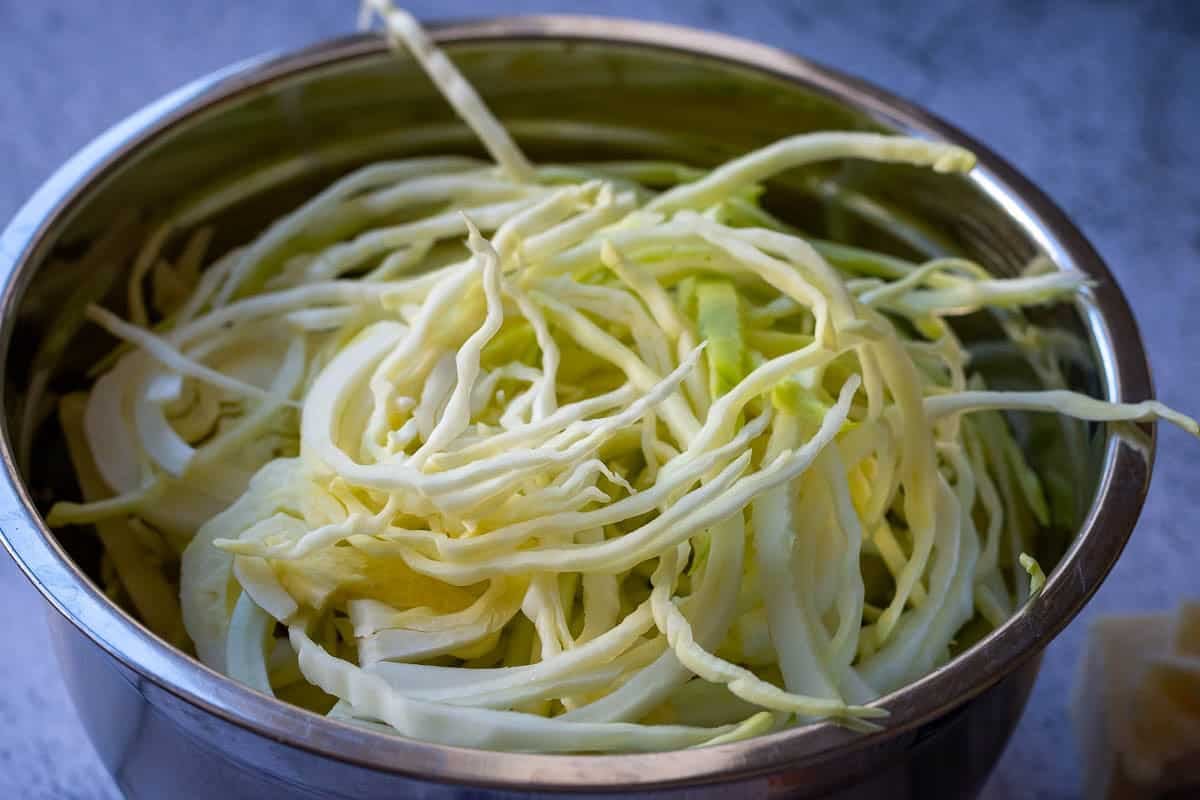 Cabbage cut into ribbons in a metal bowl.