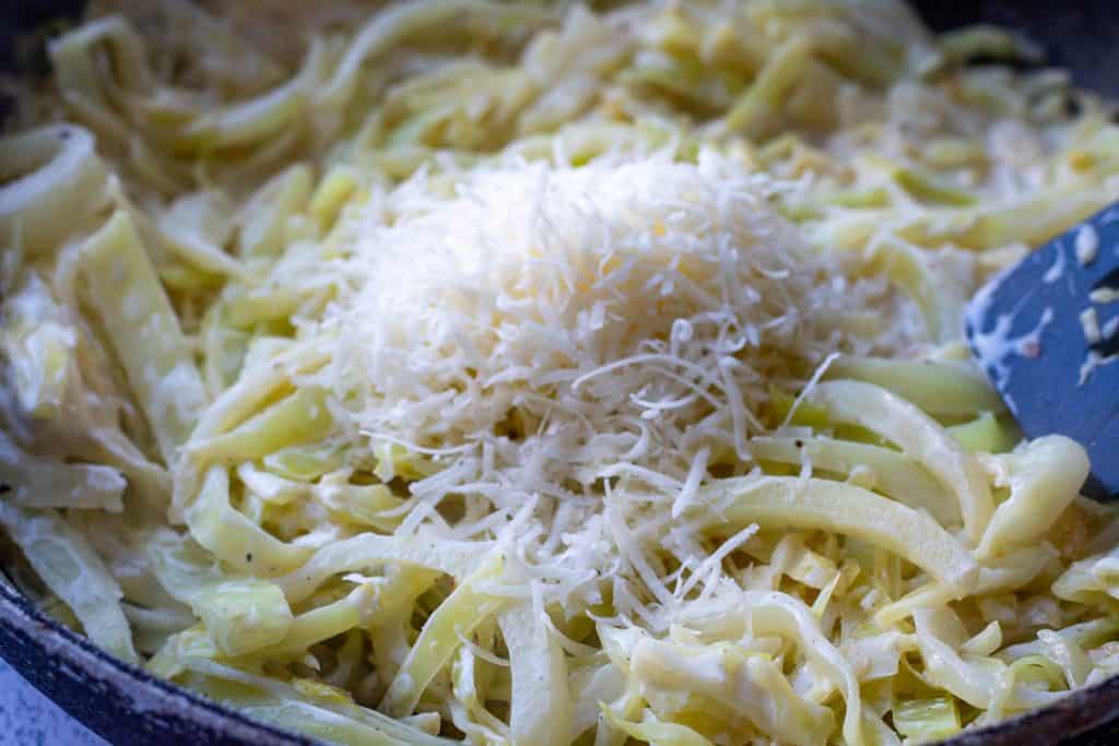 Grated parmesan added to cabbage alfredo.