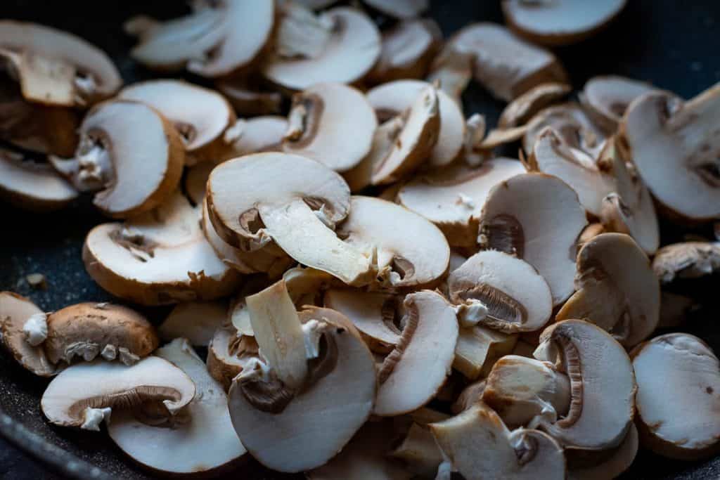 Sliced mushrooms in a frying pan.
