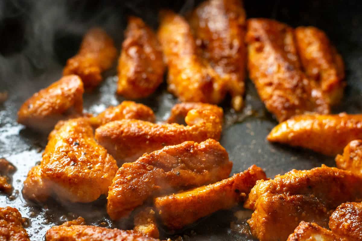 Blackened fish in a frying pan.