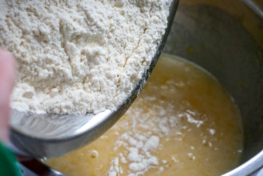 Adding dry ingredients to the wet ingredients.