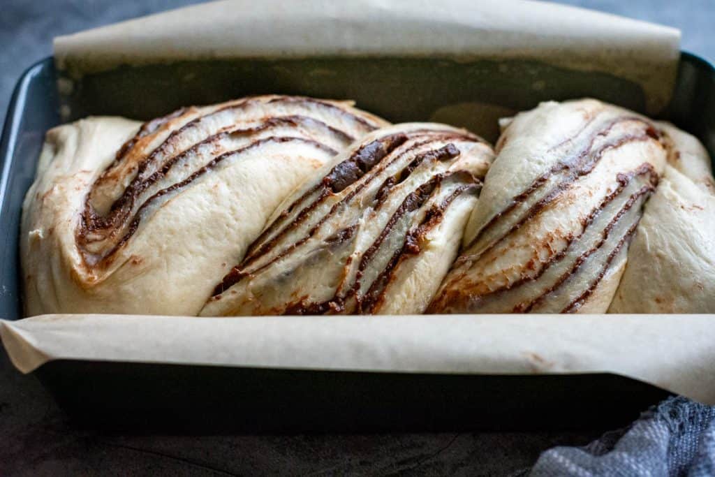 Chocolate sourdough babka proofing in a loaf pan.