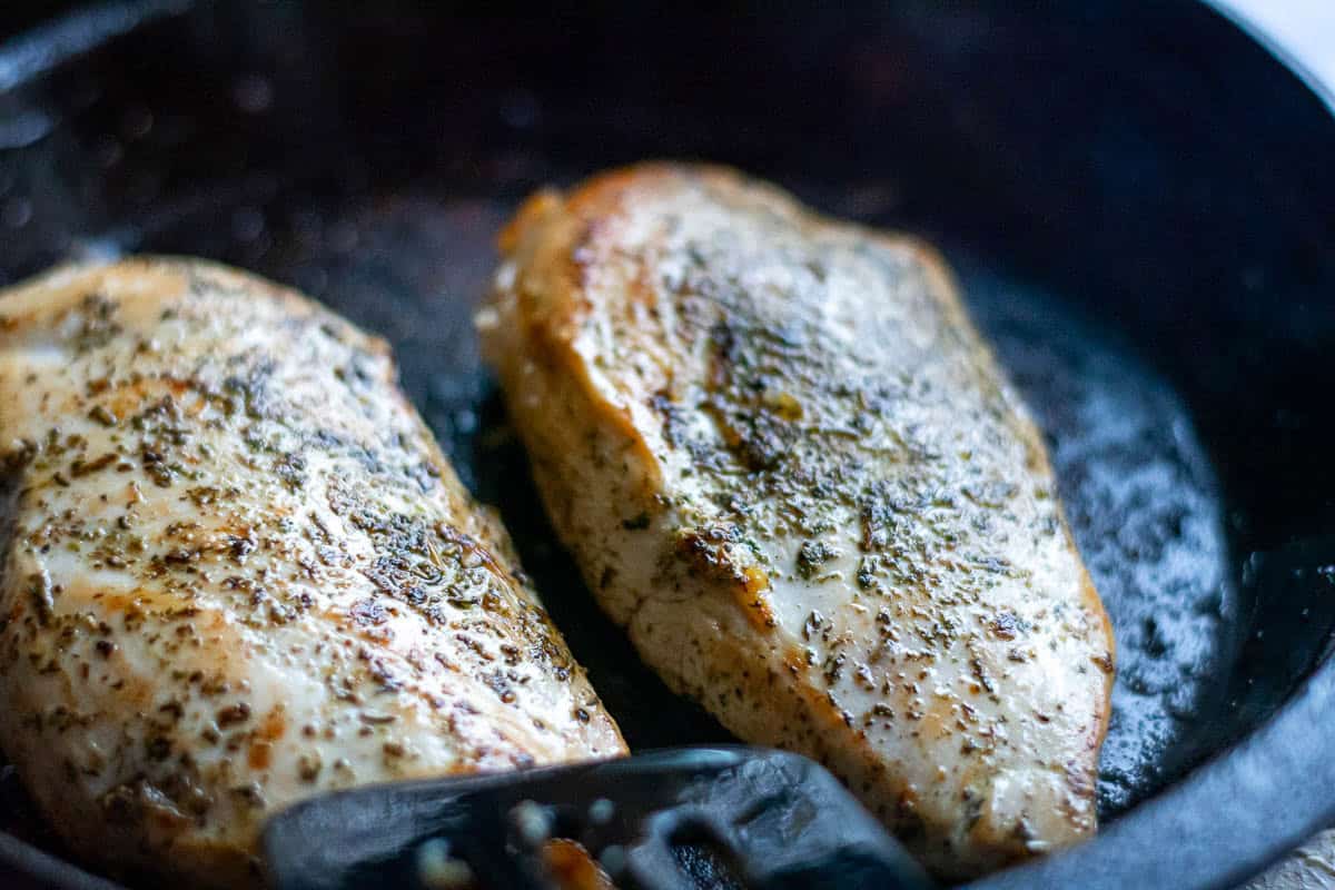 Seared chicken breasts in a cast iron pan.