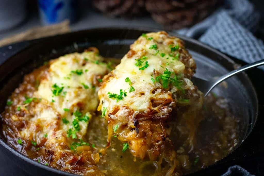 Lifitng a French Onion chicken breast out of the cast iron skillet.