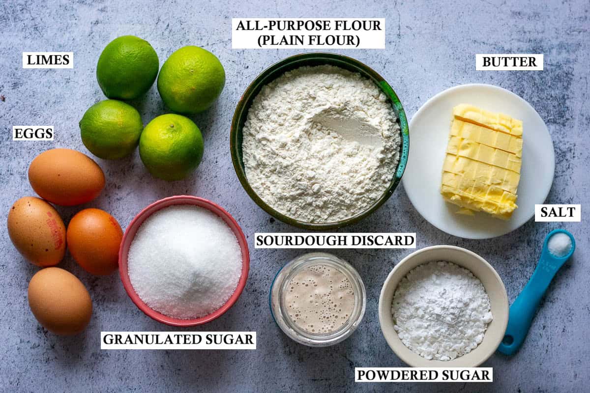 Labelled ingredients for Sourdough Discard lime Bars on a light grey surface.