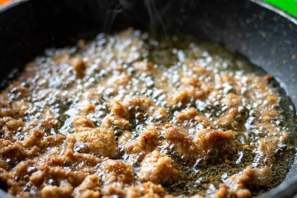 Crispy beef frying in the pan.