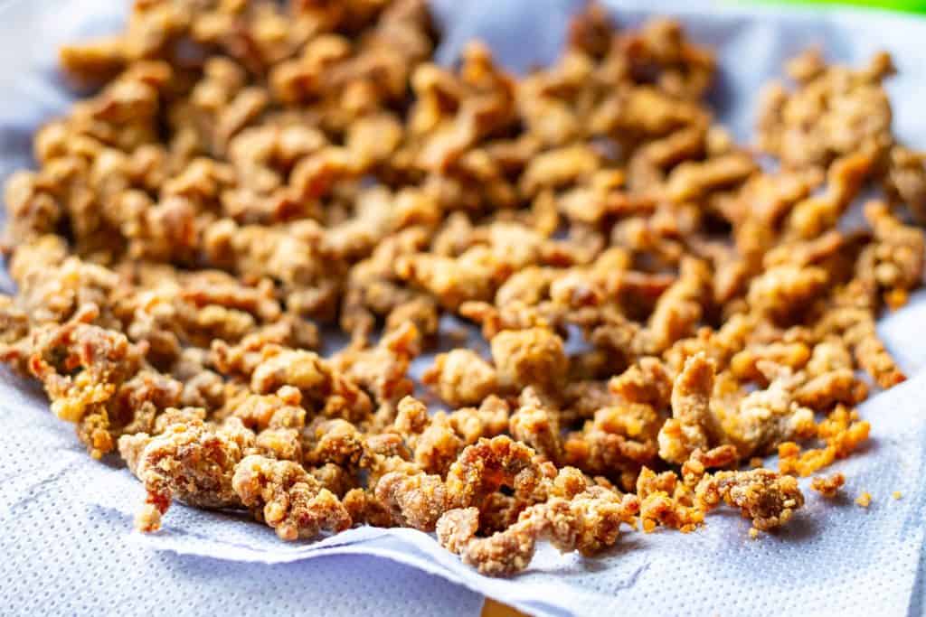 Crispy beef on a paper lined plate.