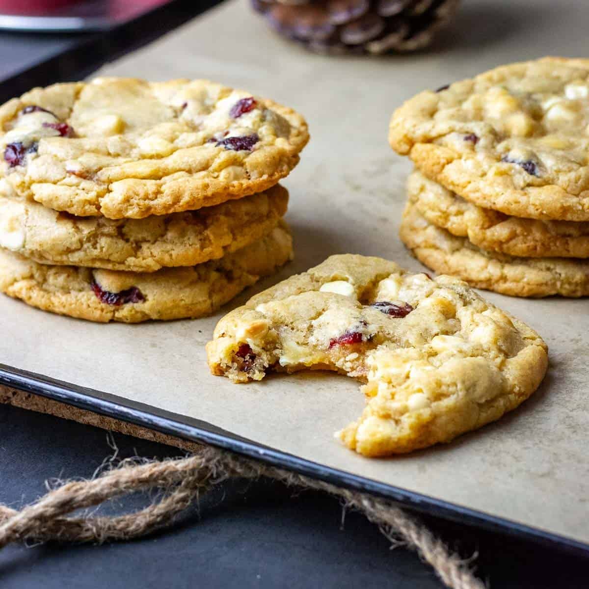 Sourdough Cranberry White Chocolate Chip Cookies stacked on a baking sheet.