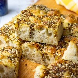 Manakeesh-inspired Za'atar Sourdough Focaccia cut into squares on a wooden board.