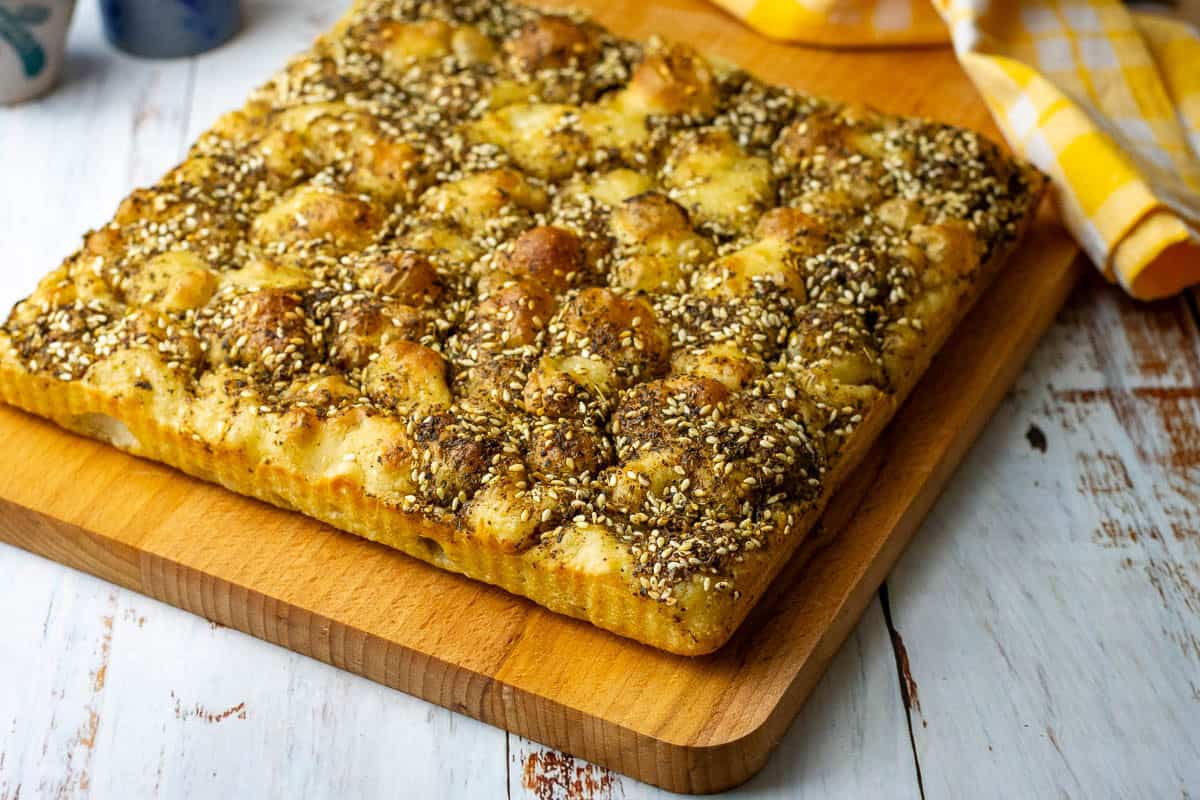 Zaatar topped Sourdough Focaccia on a wooden board.