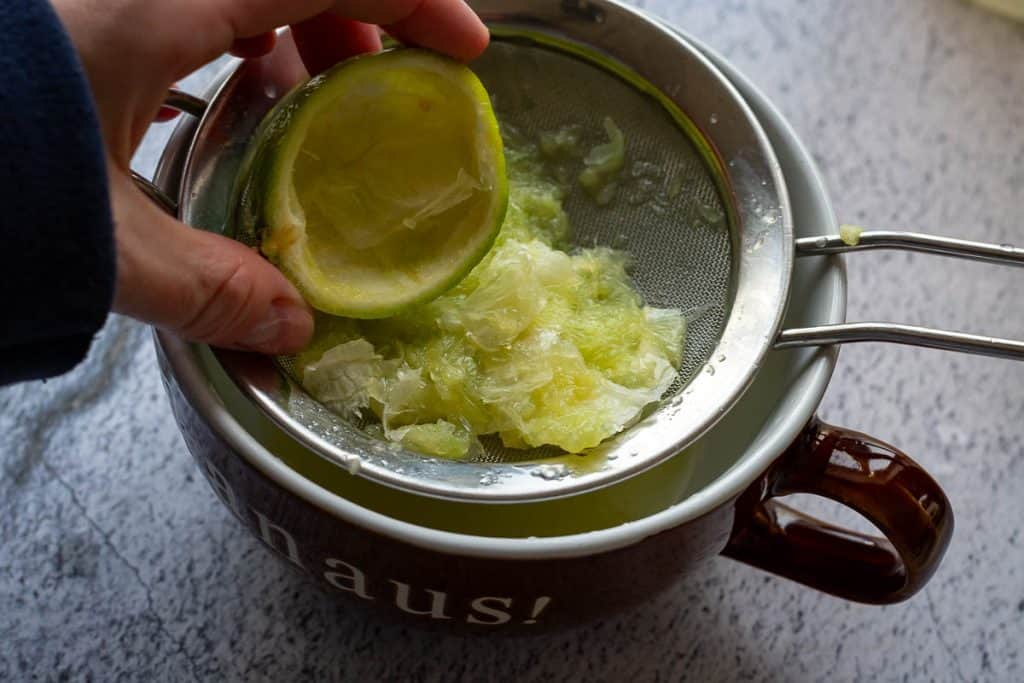Hollowing the limes into a fine mesh sieve.