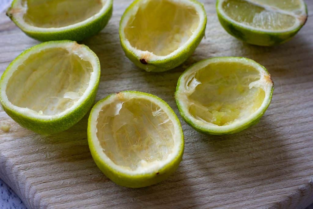 Hollowed lime shells on a wooden board.
