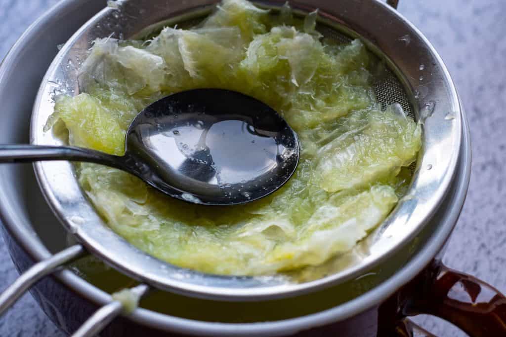 Squeezing Lime pulp through a fine mesh sieve.