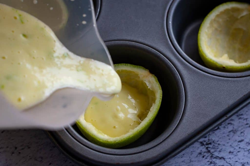 Filling lime shells with lemon posset mixture.