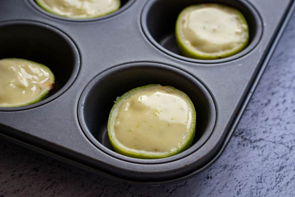 Filled lime shells in a muffin pan.