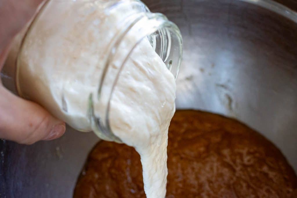 Pouring sourdough discard into the sourodugh cookie batter.
