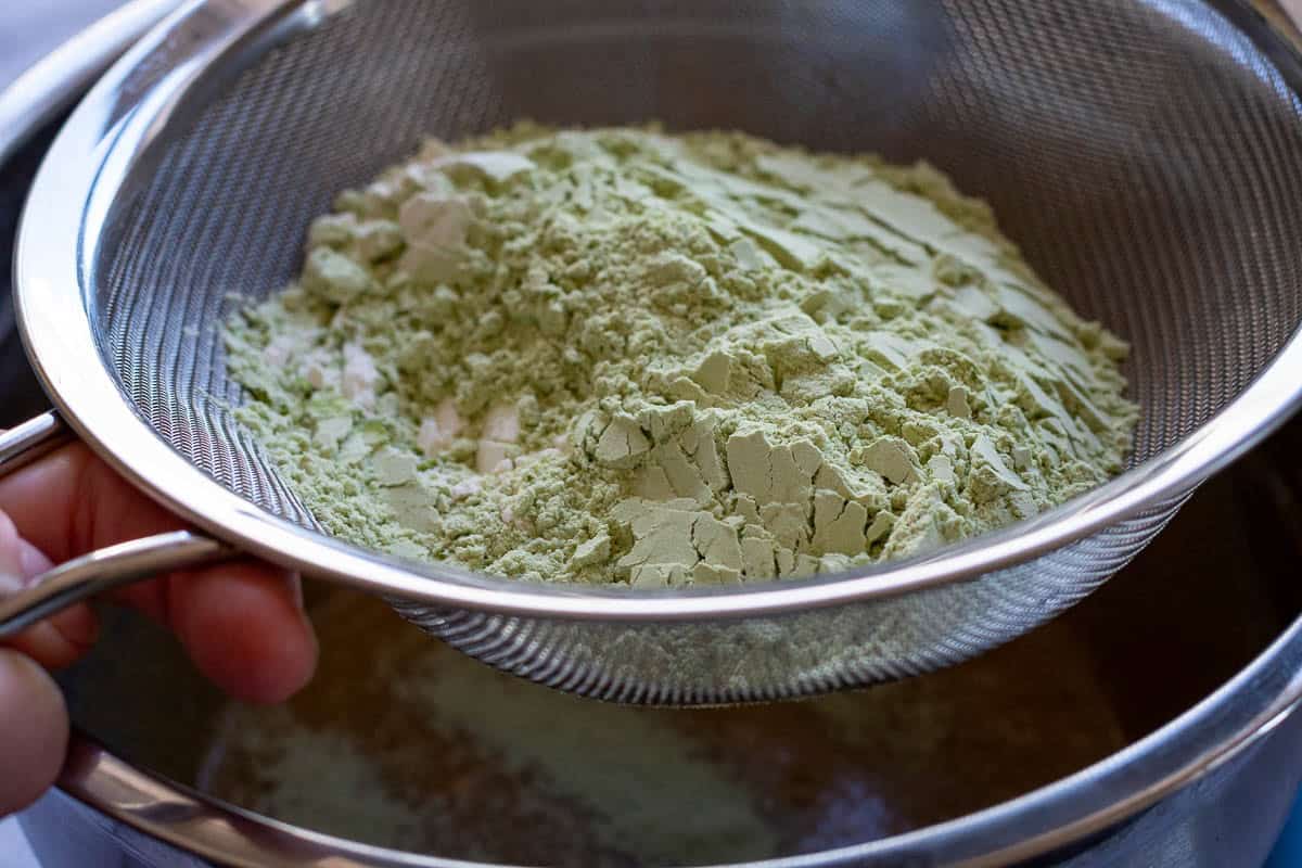 Sifting the flour and matcha powder into the wet ingredients.