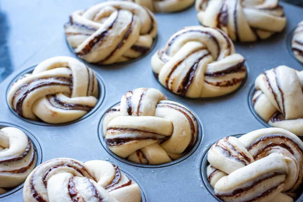 Sourdough chocolate buns in a muffin pan after second rise.