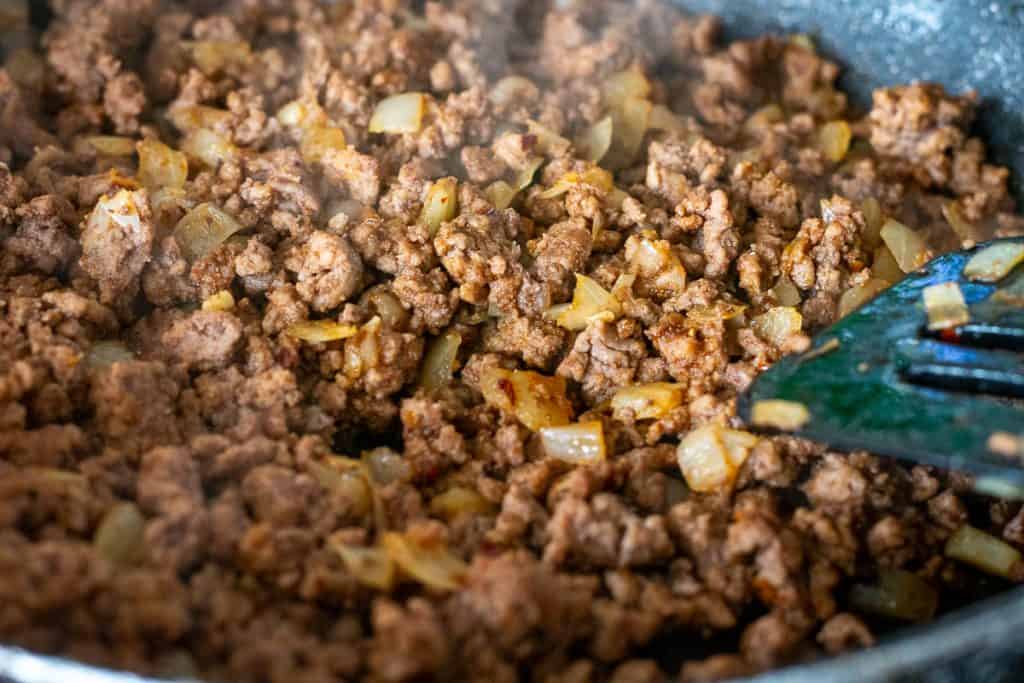 Browned beef mince and onions in a frying pan.