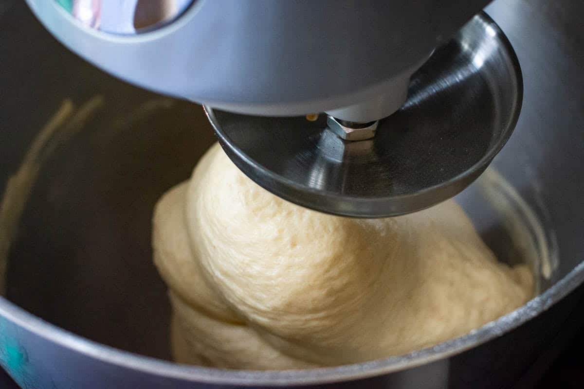 Sourdough wrapping around the dough hook attachment in a stand mixer.