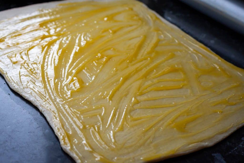 Lemon curd spread on rolled out sourdough