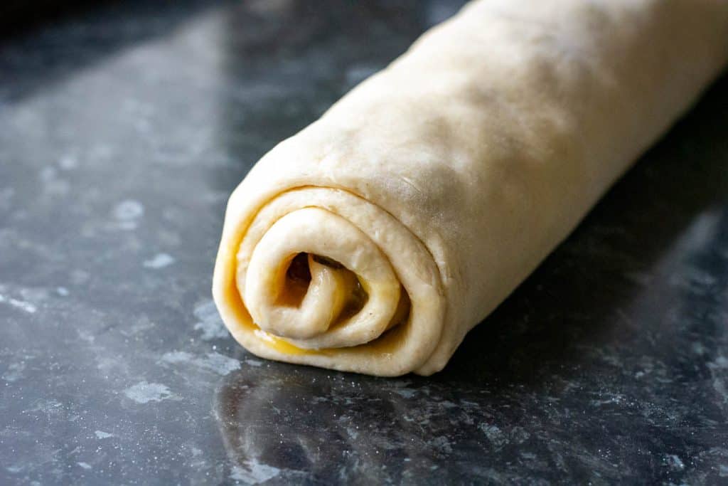 A tight roll of sourdough with lemon curd and raisins inside.