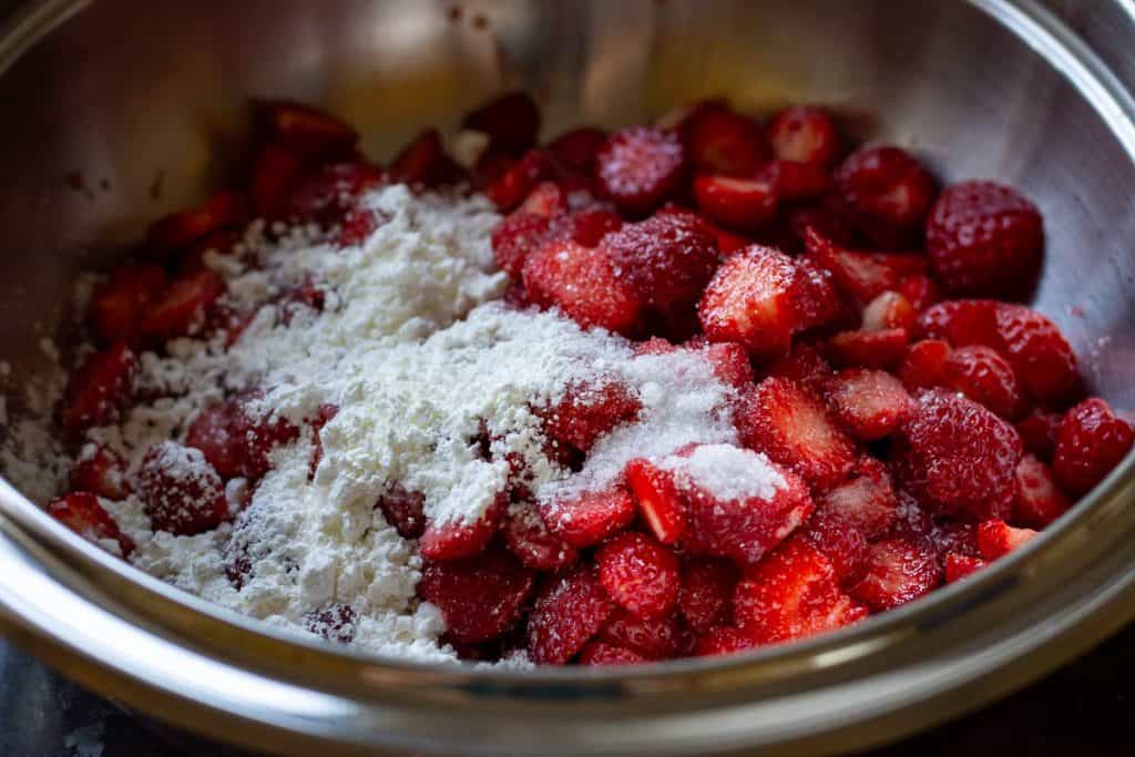 Adding sugar and cornflour to strawberries to make a filling for sourdough galette.