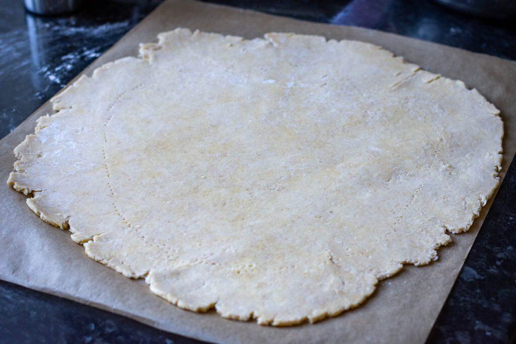 Rolled out sourdough discard pastry on a sheet of parchment paper.