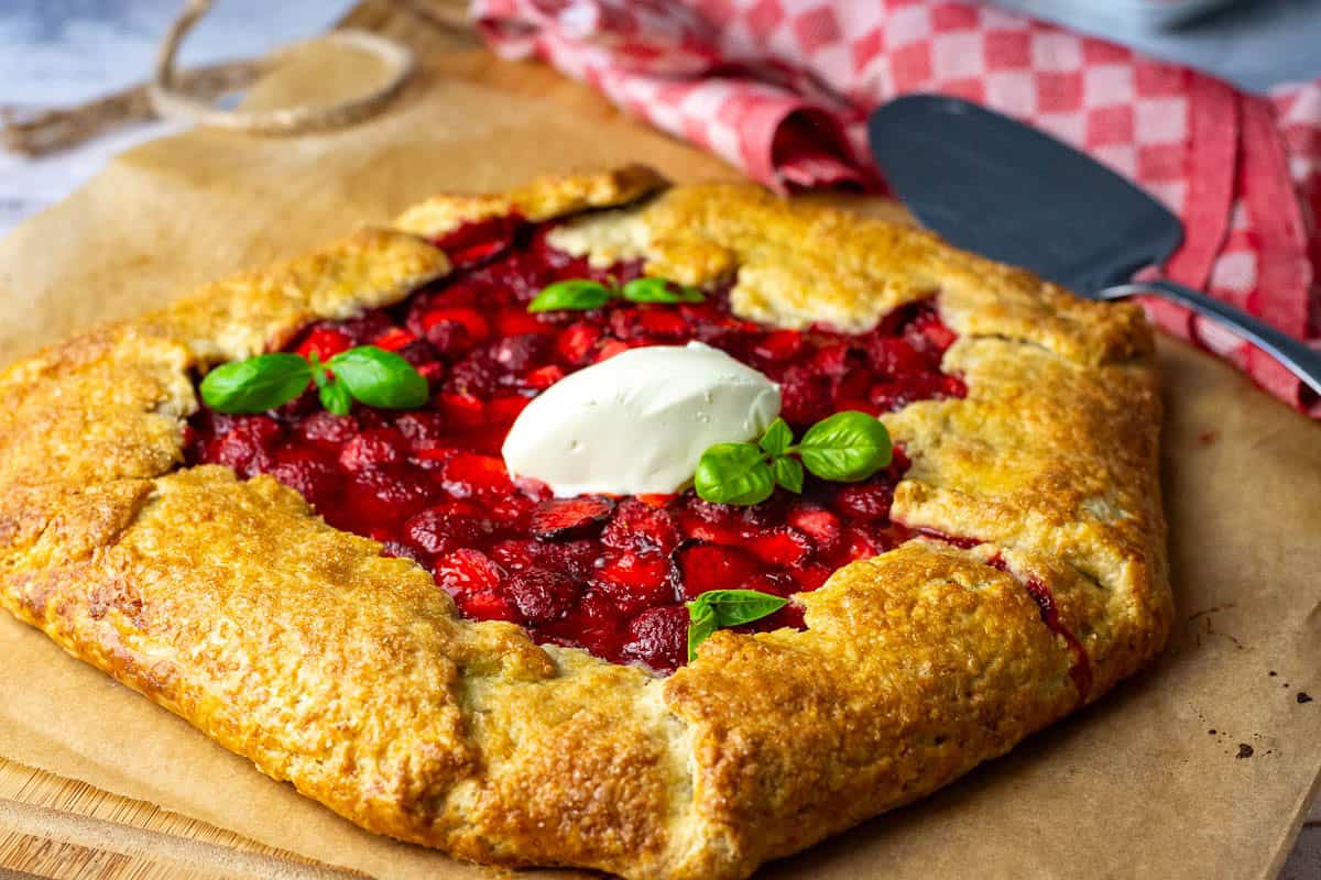 Sourdough Strawberry Galette with a dollop of creme fraiche sprigs of basil.