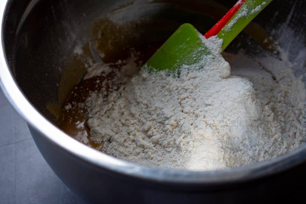 Folding dry ingredients into the wet ingredeints to form a sourdough cookie dough.
