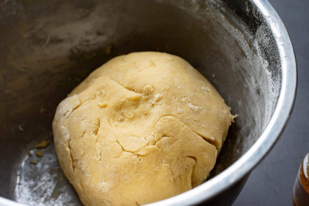 Sourdough cookie dough ball in a metal mixing bowl.