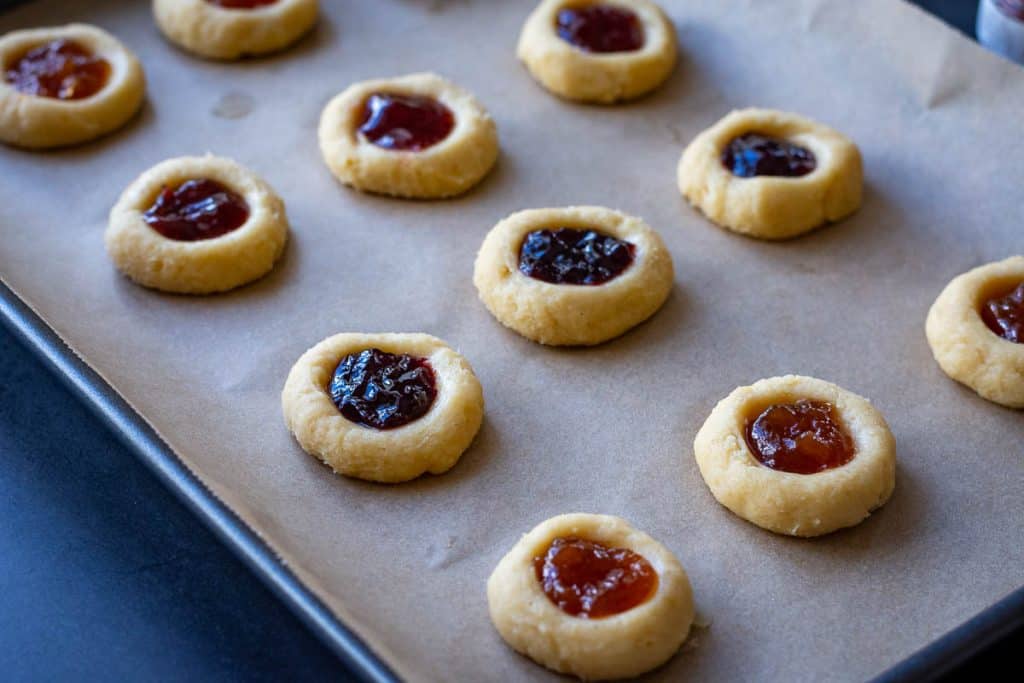 Chilled sourdough discard thumbprint cookies filled with various jams ready for baking.