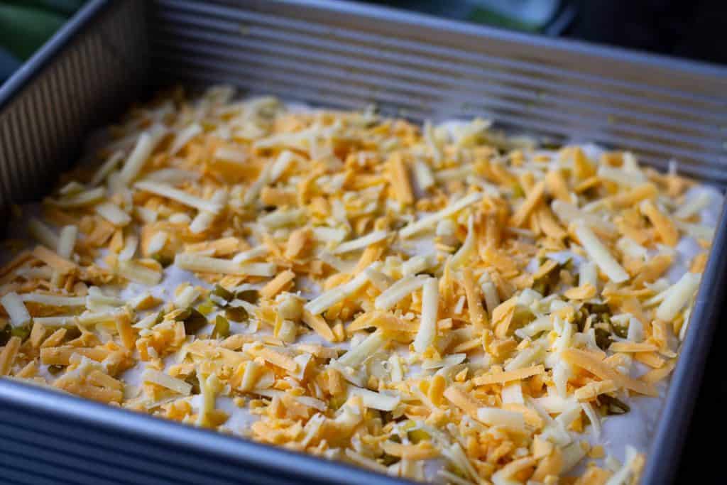 Chopped jalapenos and grated cheddar scattered on top of the focaccia.
