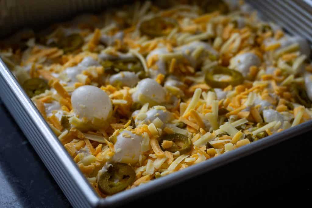 Dimpled jalapeno and cheddar sourdough focaccia topped with jalapeno slices, ready for baking.