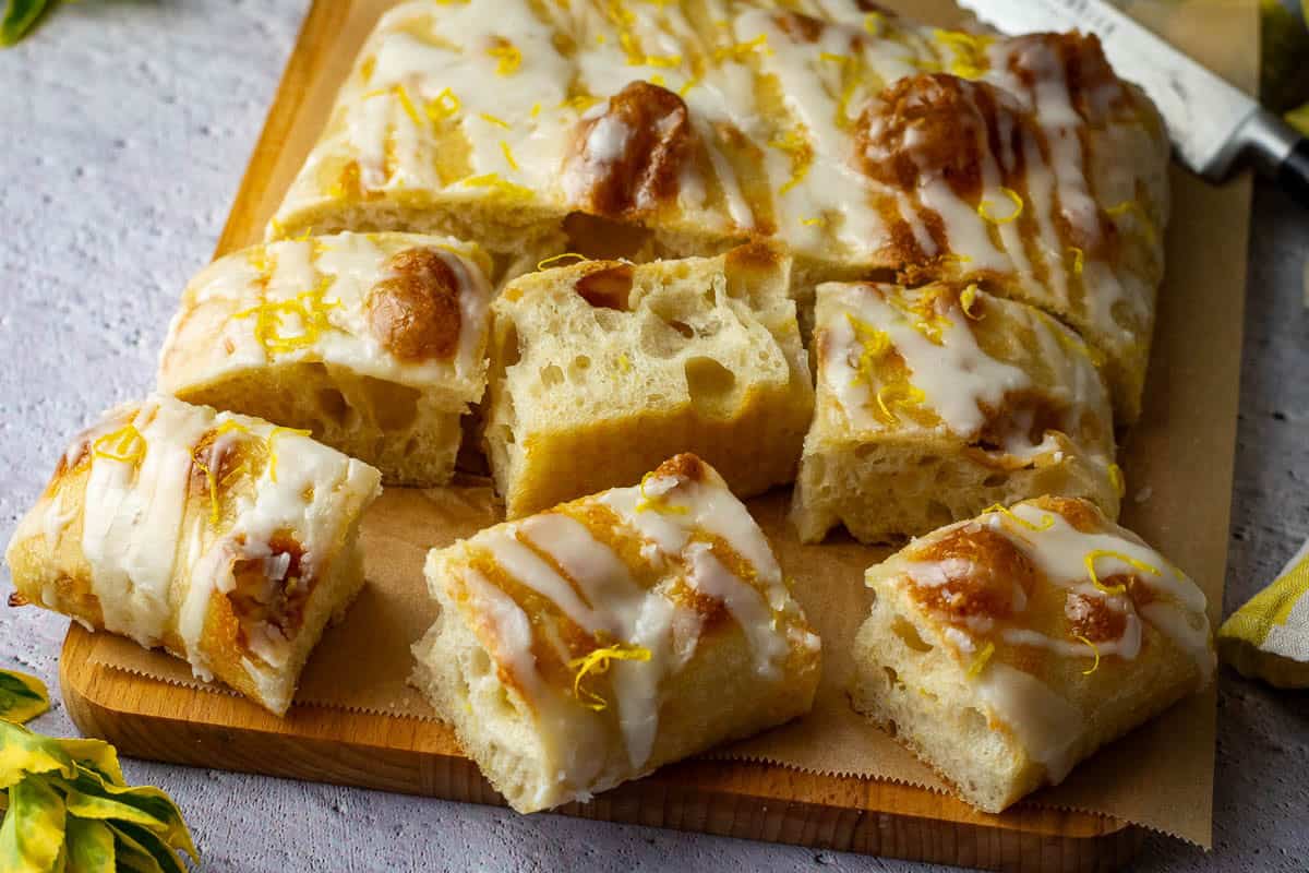 Sweet Sourdough Focaccia with Lemon filling and glaze sliced and placed on a wooden board.