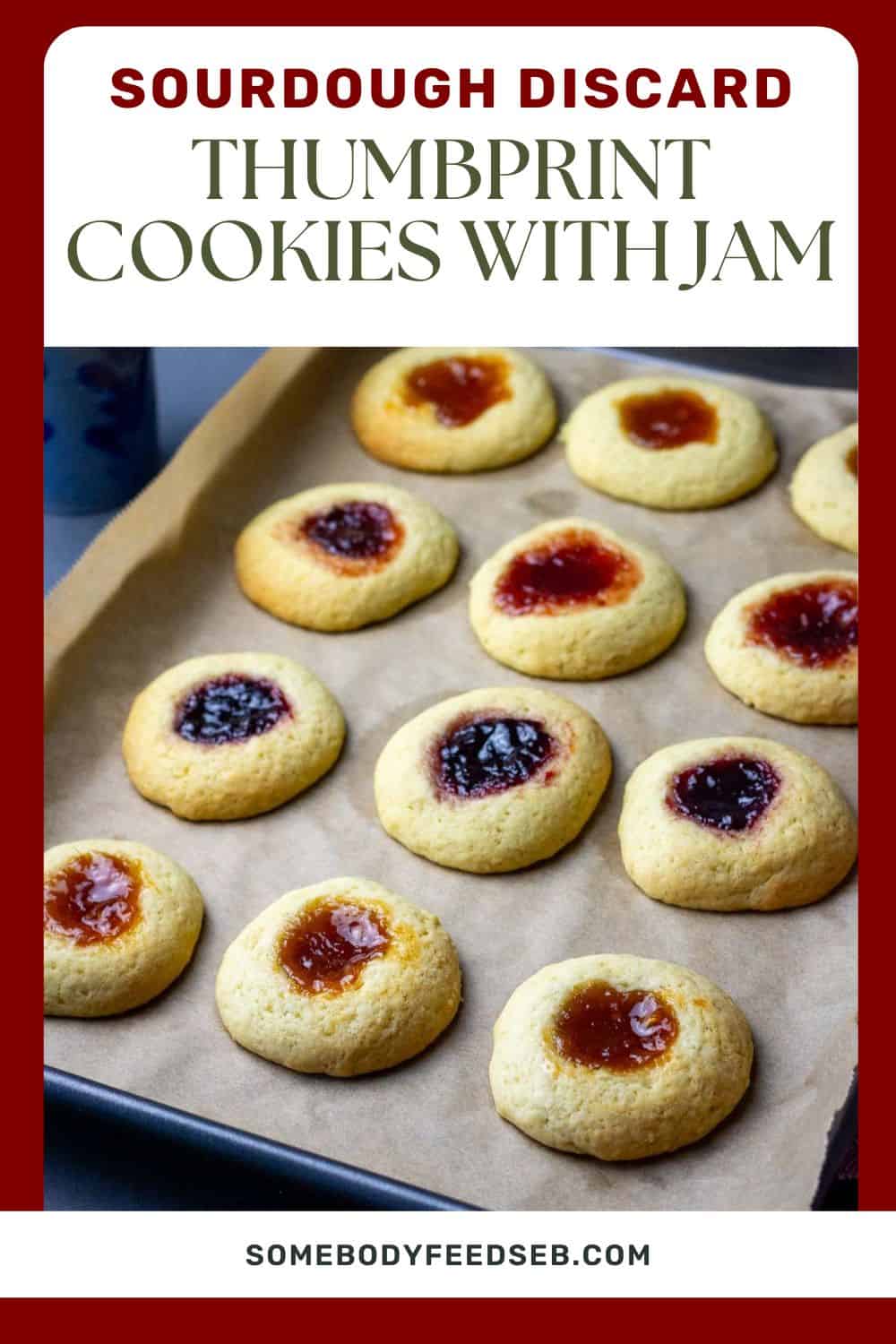 Sourdough Discard Thumbprint Cookies with Jam on a baking sheet lined with parchment paper. Pin for Pinterest.