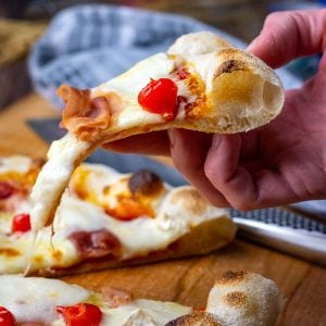 A slice of Neapolitan style sourdough pizza being pulled out.