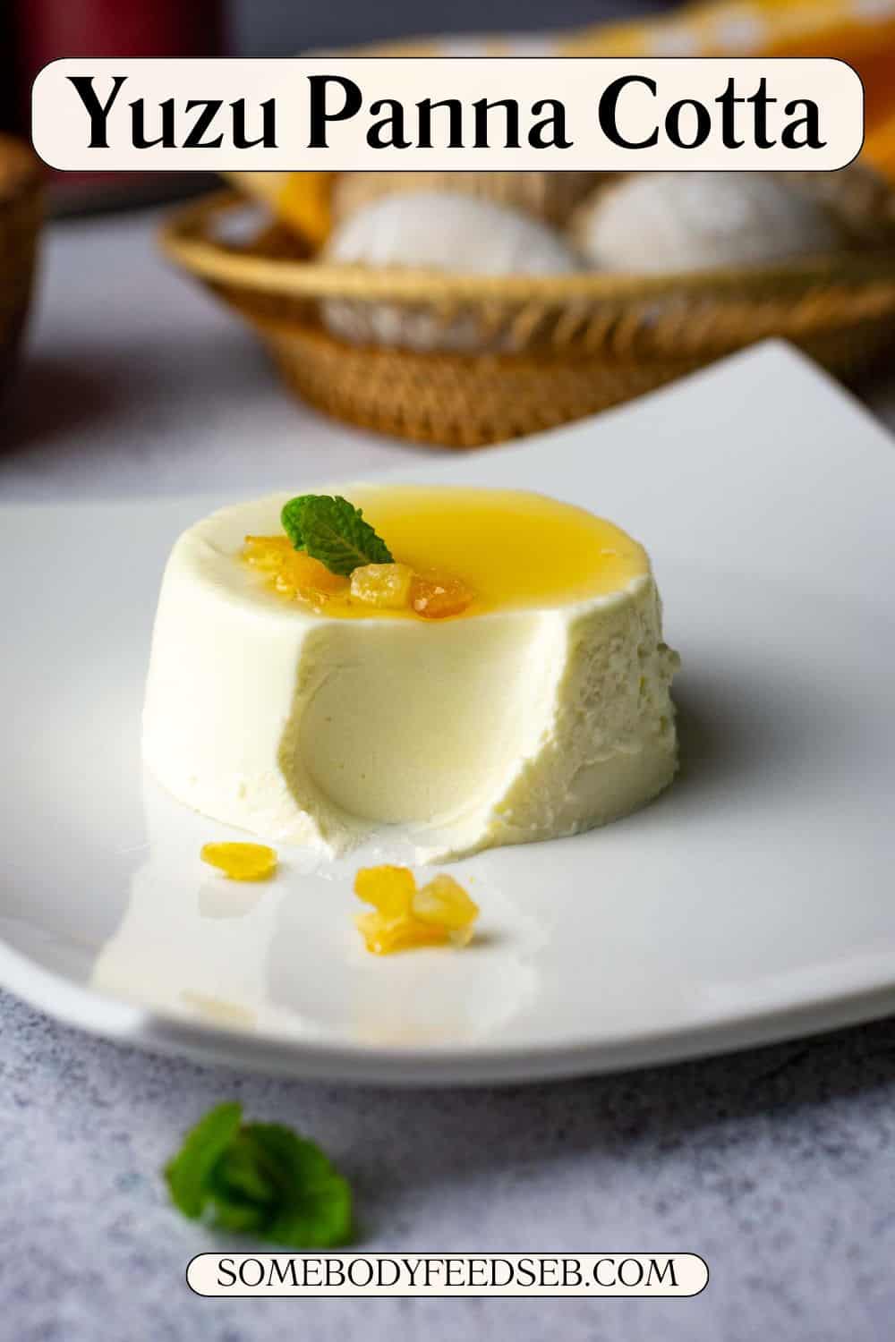 Yuzu panna cotta topped with yuzu syrup and candied peel on a white plate missing a spoonful. Pin for Pinterest.